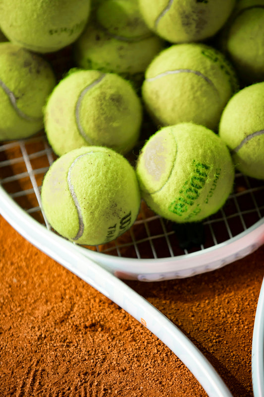 a bunch of tennis balls sitting on a racket