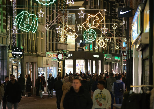 a group of people walking down a street at night