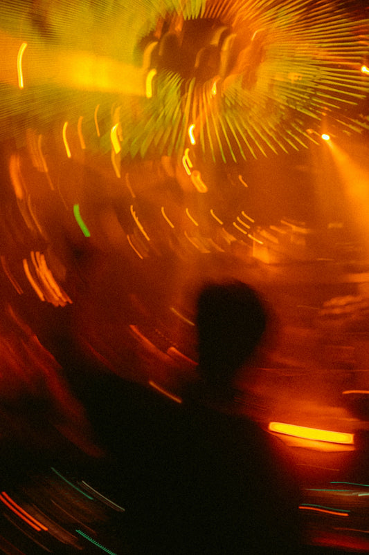 A blurry photo of a person standing in front of a firework display
