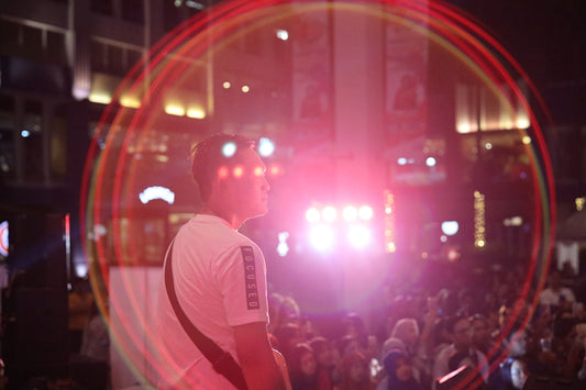 man in white dress shirt standing on stage