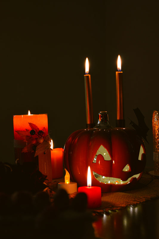 a lighted pumpkin with candles in front of it