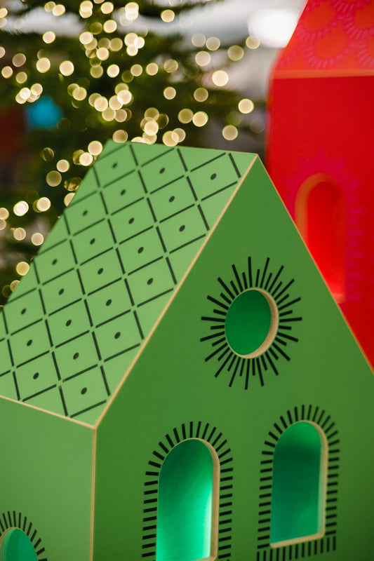 a green house with a christmas tree in the background