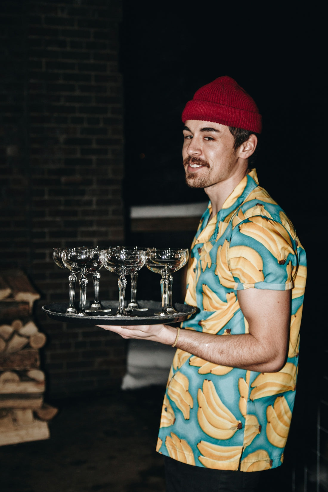 A man holding a tray of wine glasses