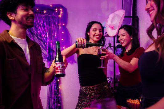 Friends are enjoying a party, pouring wine.
