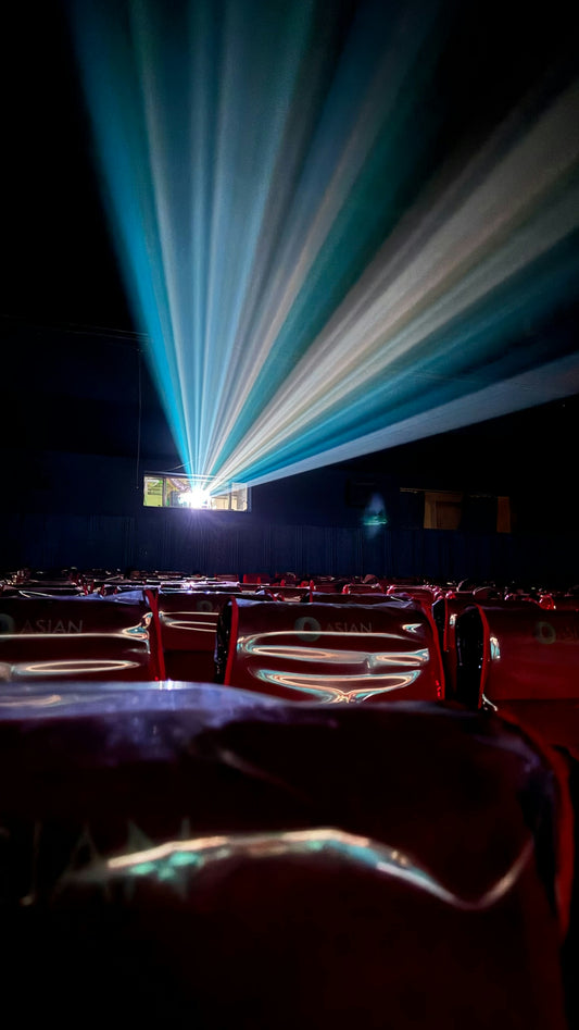 Projector light beams illuminate an empty cinema auditorium