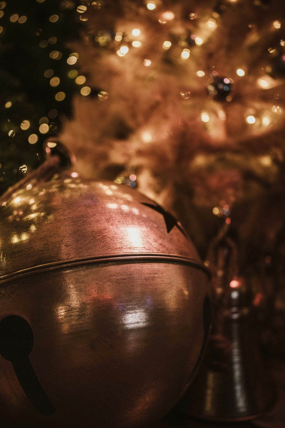 Close-up of a large jingle bell with bokeh lights