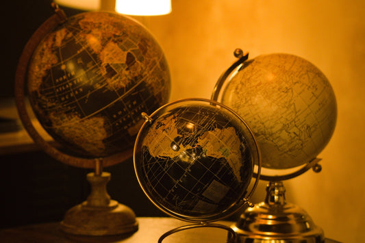 Three antique globes on a table